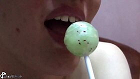Slim girl sucks lollipop while fingering wet pussy