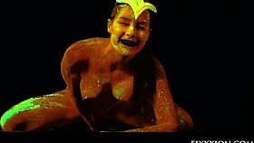 The glow in the dark goddess fingers her shaved pussy with a dildo.