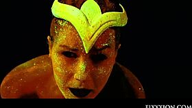 The glow in the dark goddess fingers her shaved pussy with a dildo.