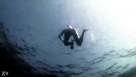 Blonde girl in bikini swims in supernatural setting