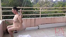 Depraved housewife swings naked under an umbrella in the rain. Full retro video of wild antics!