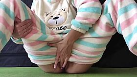 Teen in pajamas masturbates her small 18+ tits and pussy, squirting in orgasm.
