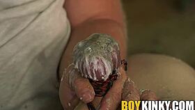 this gay guy gets his balls waxed and cock stroked in bondage