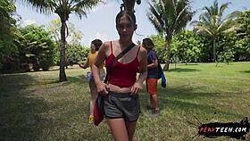 two people engage in intimate activities in a public park despite passersby