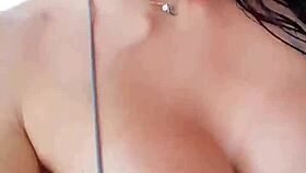 A European beauty in a silver bikini pleasures herself
