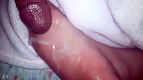 A close-up of oiled feet receiving a warm liquid splash.