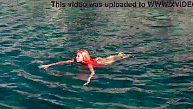 Blue water surrounds a naked skinny girl flashing outdoors