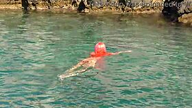 Blue water surrounds a naked skinny girl flashing outdoors