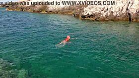 Blue water surrounds a naked skinny girl flashing outdoors