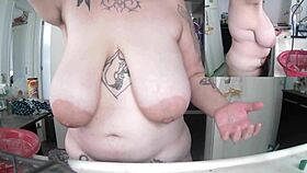 Chubby woman does dishes naked with saggy tits exposed