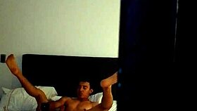 A young Colombian person is masturbating solo on vacation with his tattoos showing in the room quietly