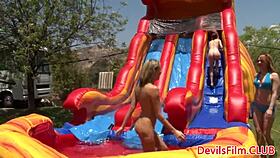 lesbian beauties playfully toy with each other's pussies outdoors