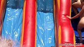 lesbian beauties playfully toy with each other's pussies outdoors