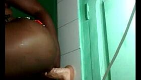 black gymnast fixes wall dildo for acrobatic lesbian toy play session