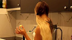 Tattooed blonde flashes meaty pussy and sexy ass in kitchen